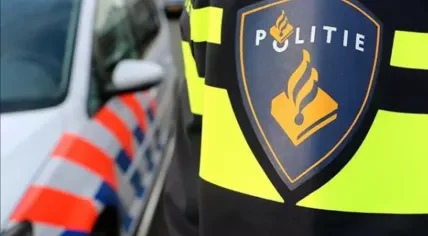 A Dutch police officer standing by a police car