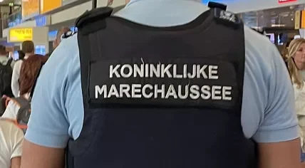 A Marechaussee officer walking through Schiphol Airport. 19 July 2024